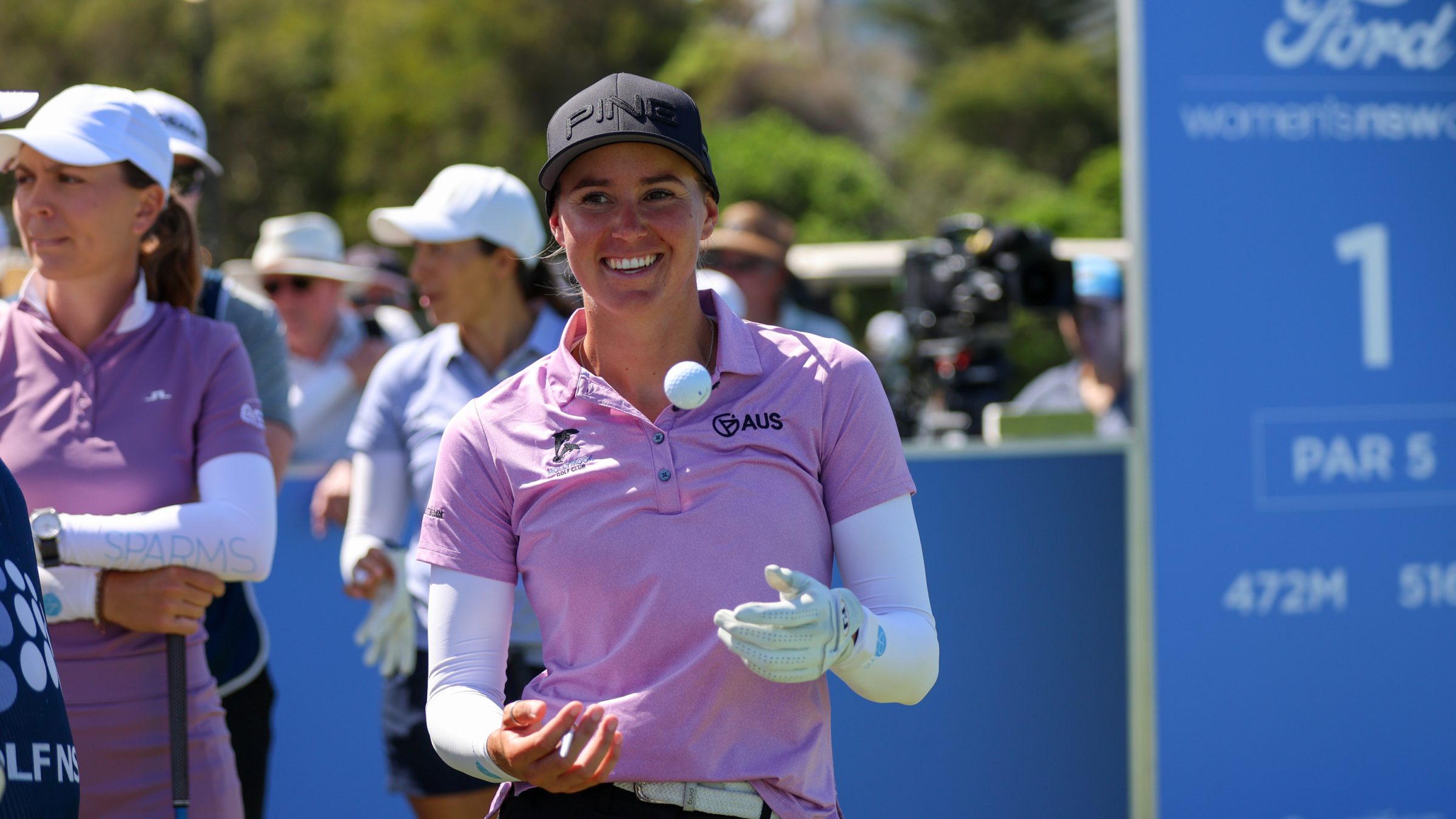 Kelsey Bennett smiling with a golf ball in the air